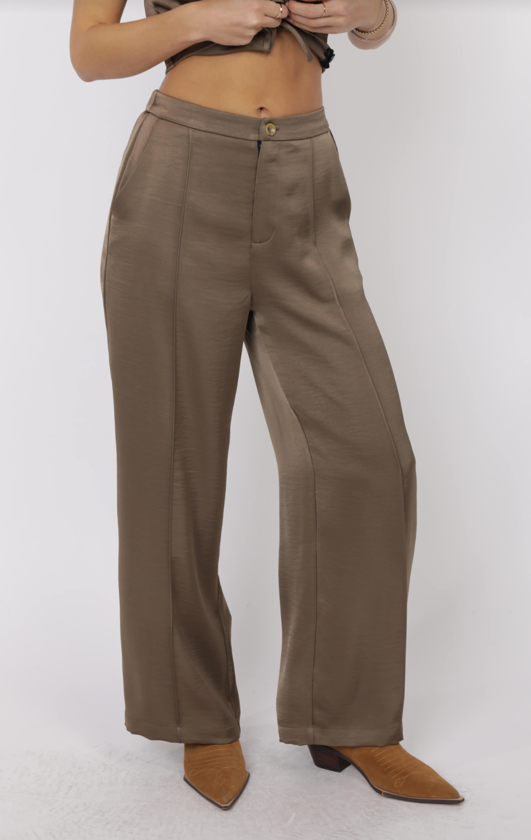 Model wearing Arizona Sky Elastic Back Waist Pant in taupe-brown polyester with tailored front, elastic back waistband, and wide-leg fit, styled with tan pointed-toe boots.