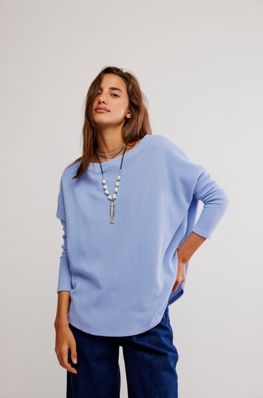 Woman wearing oversized light blue waffle knit long sleeve top with dark denim jeans