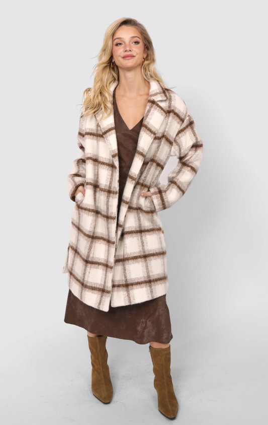 Woman wearing a long open-front plaid coat in neutral brown and cream tones.