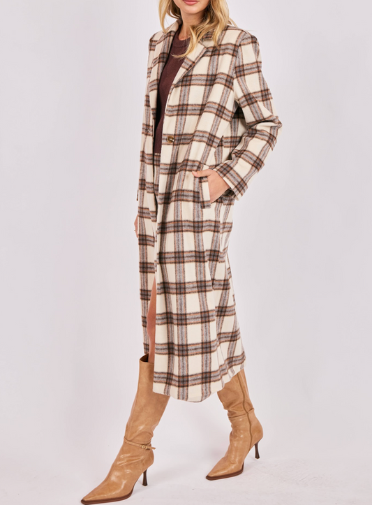 Person wearing a long plaid coat with a white background
