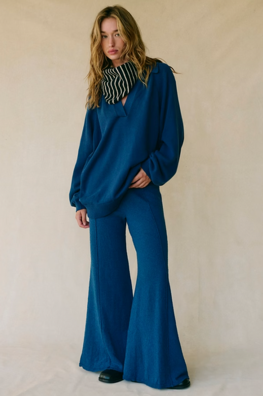 Model wearing Drea Sweater Set featuring relaxed V-neck sweater and flared knit pants in soft cotton fabric.