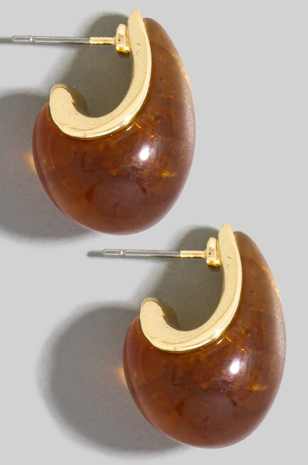 Brown hoop earrings with gold accents on a gray background
