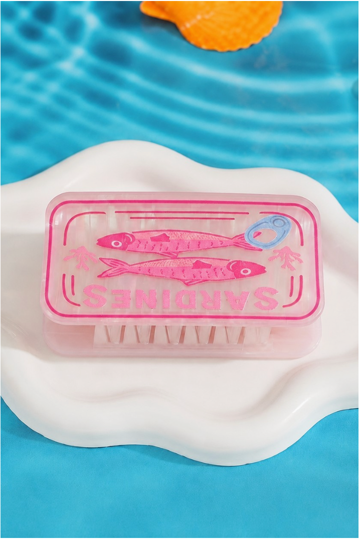 Pink vintage sardine tin inspired hair claw clip with glossy marbled acetate finish and whimsical fish illustration.