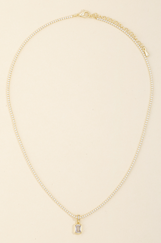 Gold pavé tennis necklace with emerald-cut cubic zirconia pendant in a bezel setting.