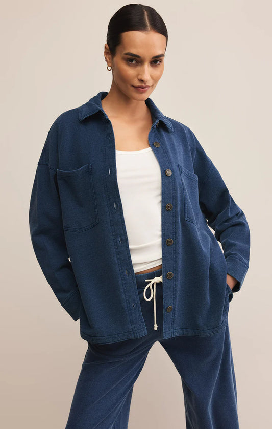 Woman wearing indigo knit denim jacket with button front and patch pocket