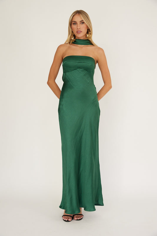 Woman wearing green satin halter neck floor-length gown with scarf tie detail.