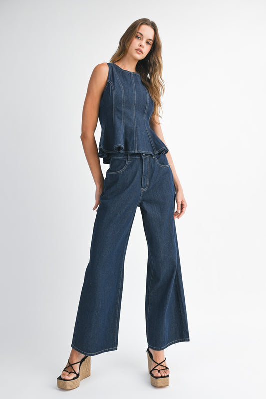 Model wearing sleeveless peplum denim top with matching wide leg jeans set.
