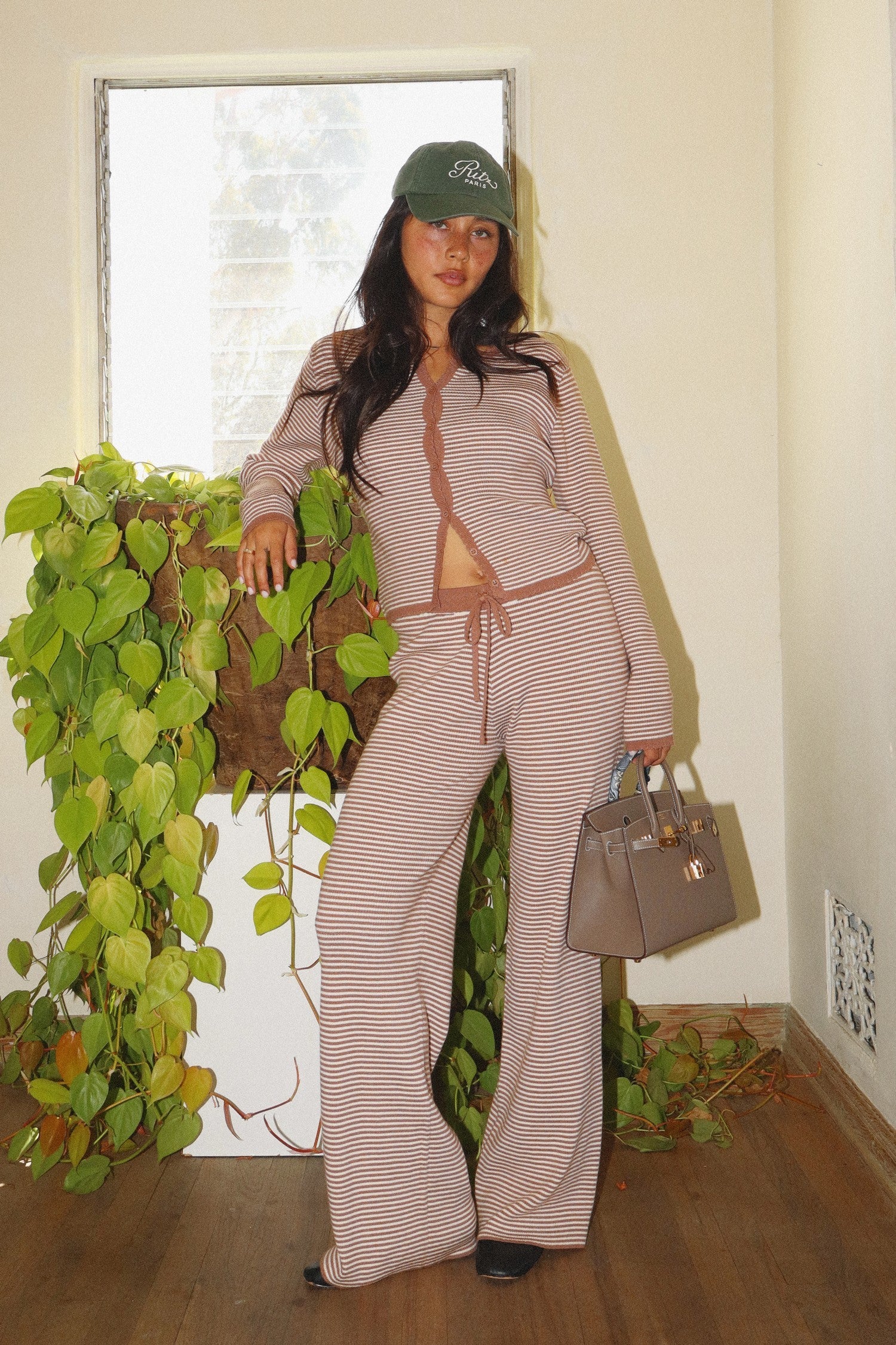 Model wearing Cocoa Stripe Lounge Pants with wide-leg silhouette and drawstring waist, styled with matching striped cardigan.