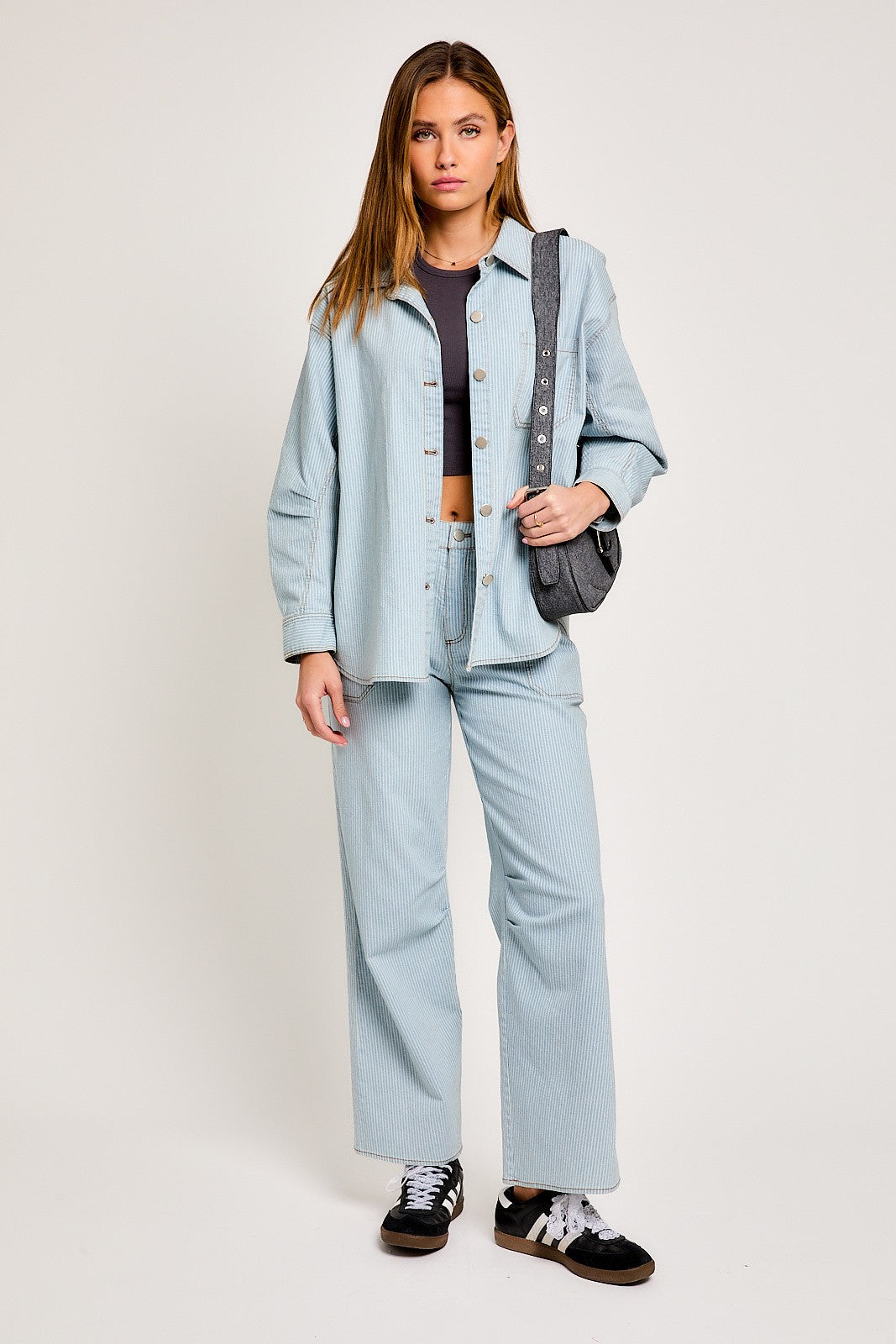Model wearing light wash wide-leg denim pants with patch pockets and relaxed fit