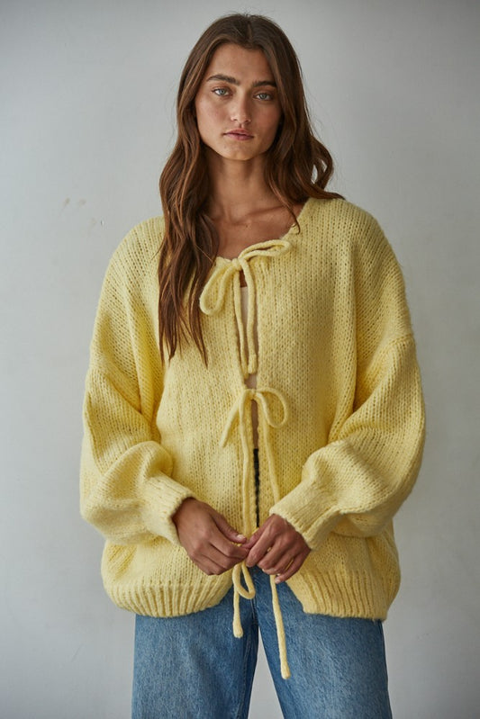 Woman wearing yellow tie front knit cardigan sweater