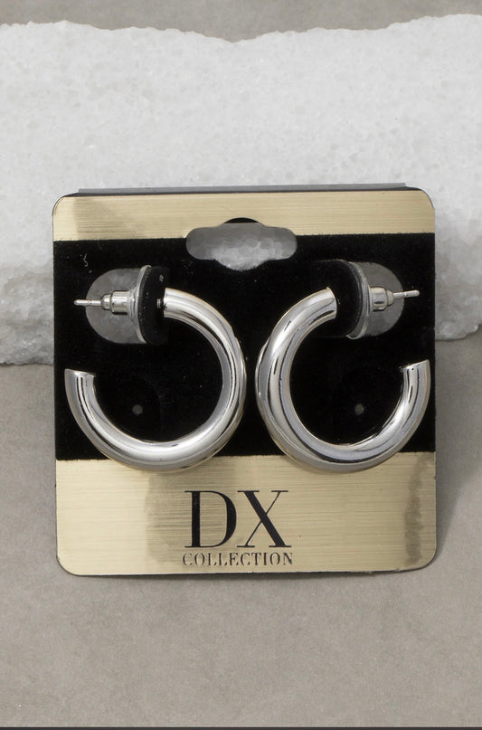 Polished silver thick tube hoop earrings with a smooth mirror finish and oversized silhouette displayed on a jewelry card