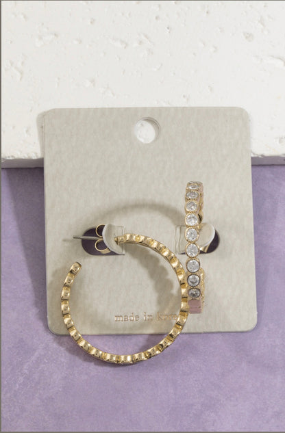 Gold hoop earrings featuring bezel-set round cubic zirconia stones with a lightly textured outer edge, perfect for everyday wear and special occasions.
