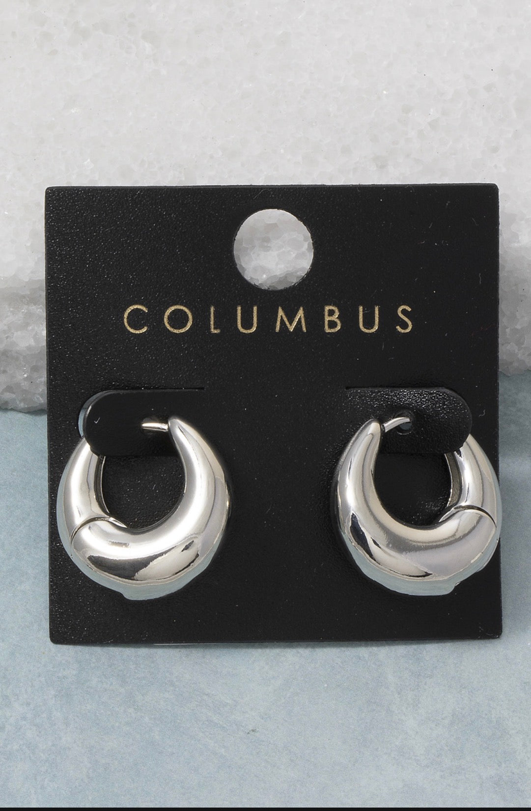 Silver dome huggie hoop earrings featuring a bold sculptural silhouette with a polished high-shine finish and hinged closure.
