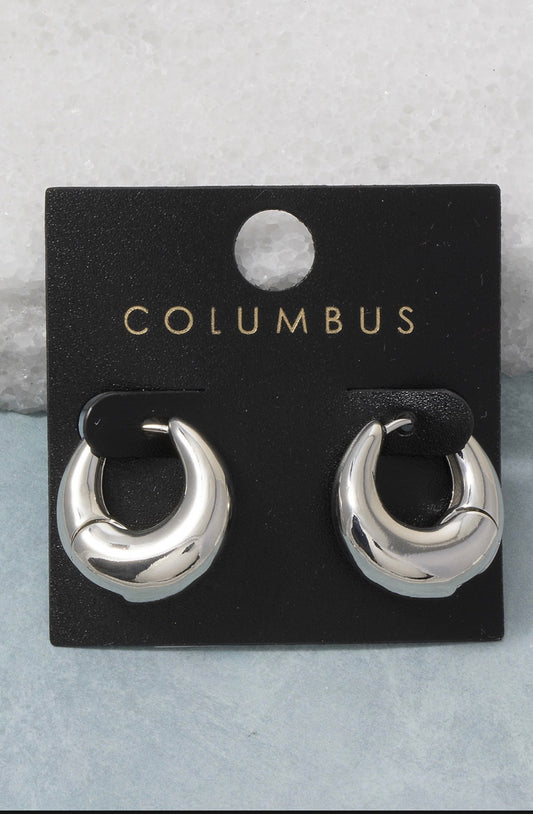 Silver dome huggie hoop earrings featuring a bold sculptural silhouette with a polished high-shine finish and hinged closure.
