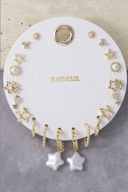 Gold-tone 8-piece celestial earring set featuring star hoops, pearl studs, sunburst studs, cubic zirconia accents, and dangling star charm earrings for mix-and-match styling.