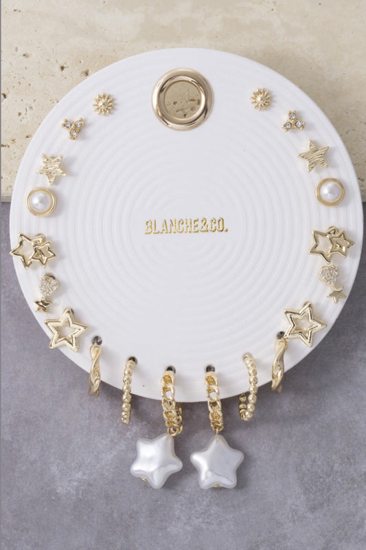 Gold-tone 8-piece celestial earring set featuring star hoops, pearl studs, sunburst studs, cubic zirconia accents, and dangling star charm earrings for mix-and-match styling.