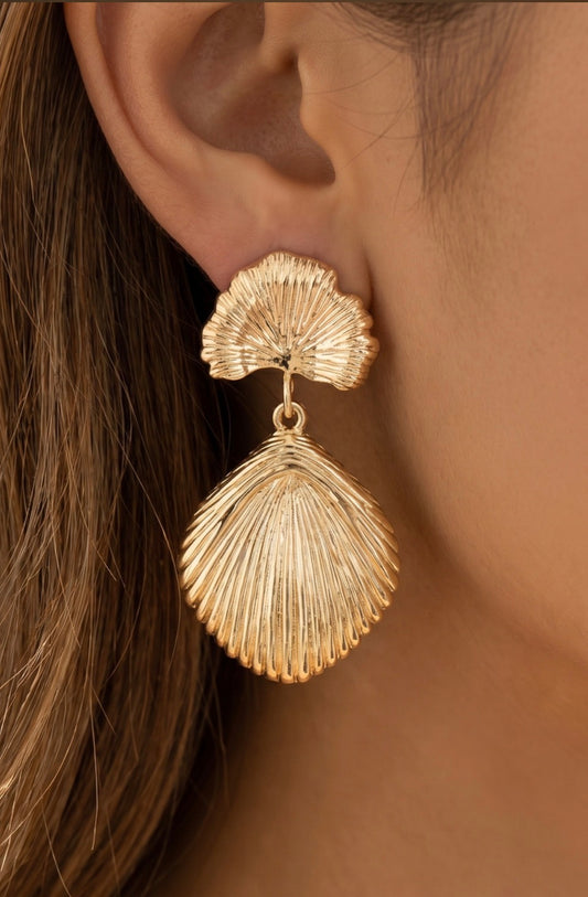 Gold shell-inspired statement drop earrings featuring a textured fan stud with a large sculpted shell pendant.