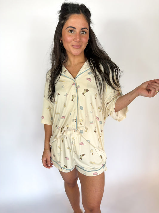 Woman wearing a cream-colored pajama set with floral patterns on a white background