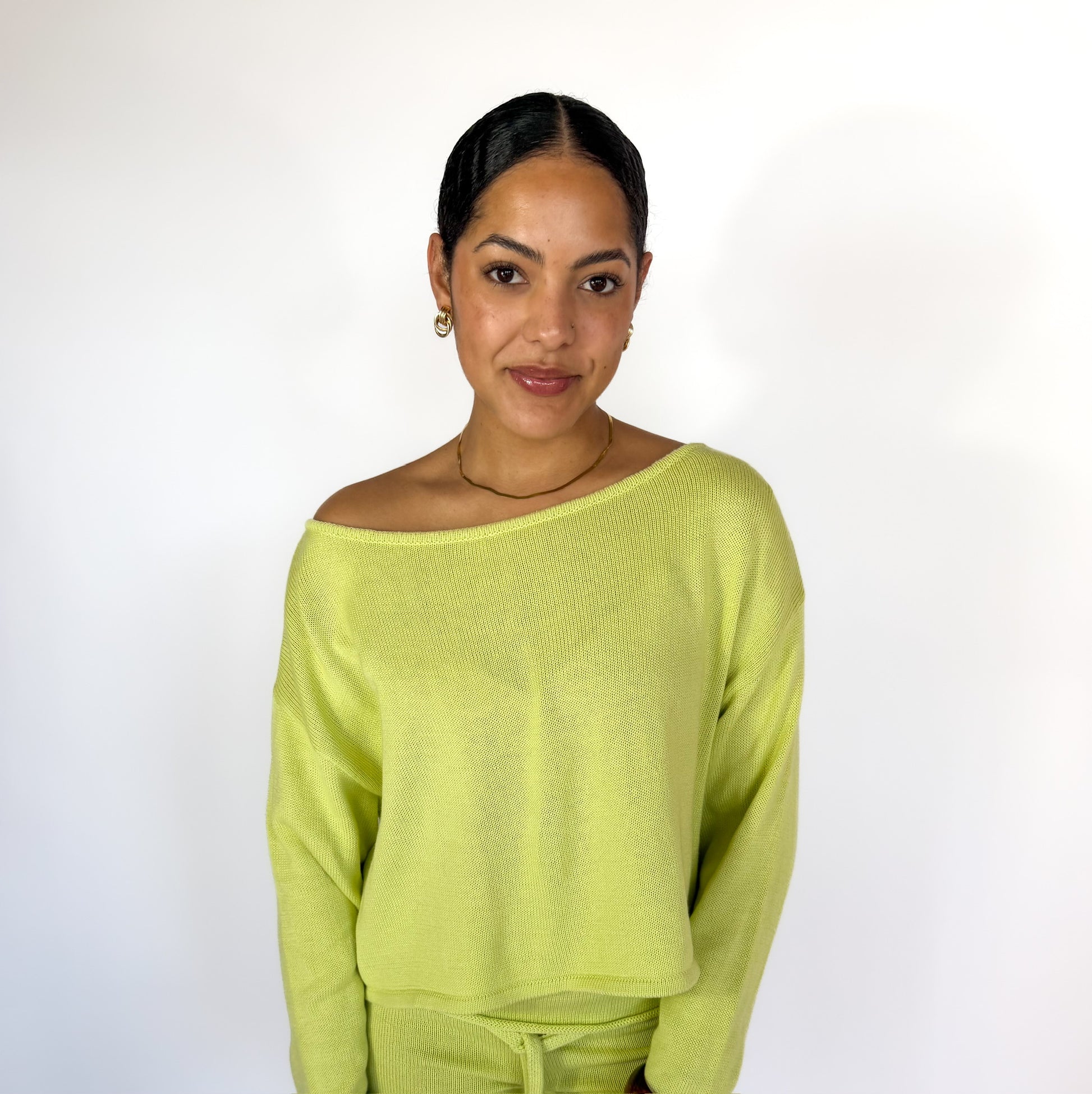 Woman wearing a light green sweater against a white background