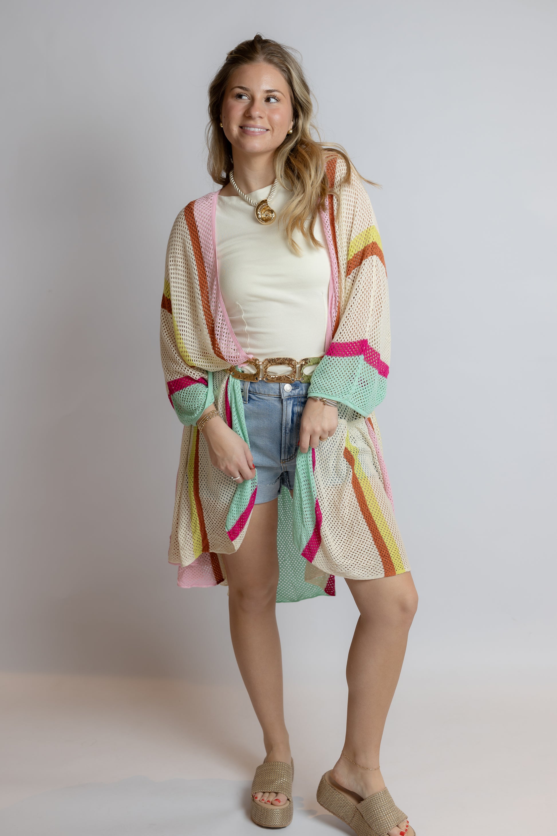 Woman wearing a colorful kimono-style garment against a plain background