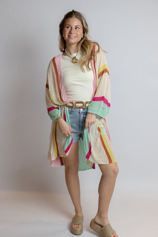 Woman wearing a colorful kimono-style garment against a plain background