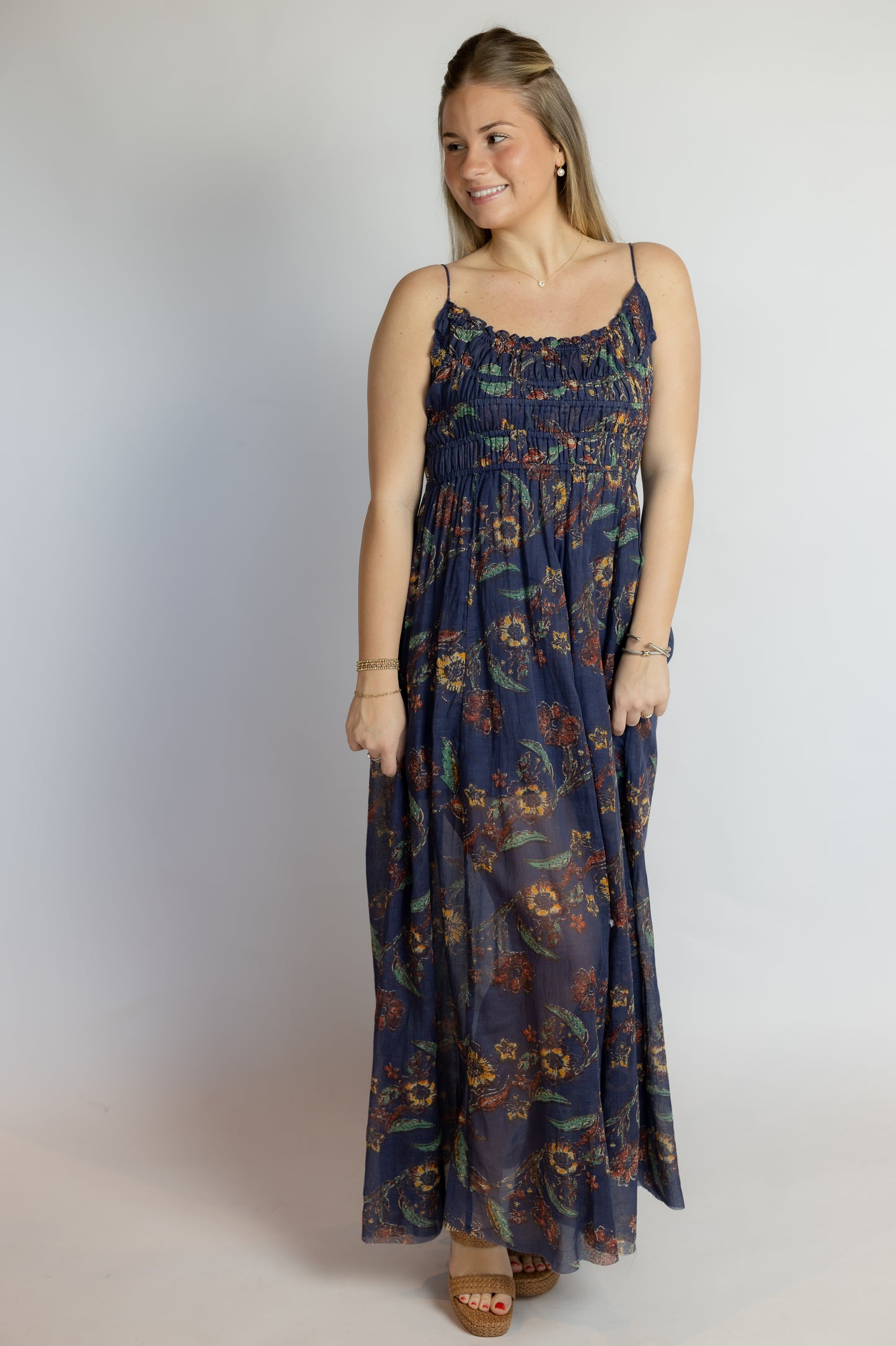 Woman wearing a floral patterned dress against a plain background