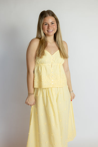 Woman wearing a yellow dress against a plain background