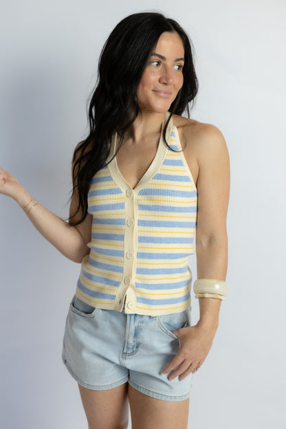 Woman wearing a striped sleeveless top and shorts on a plain background
