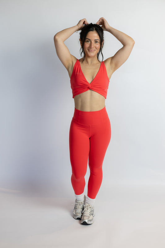 Woman wearing a red athletic outfit on a white background