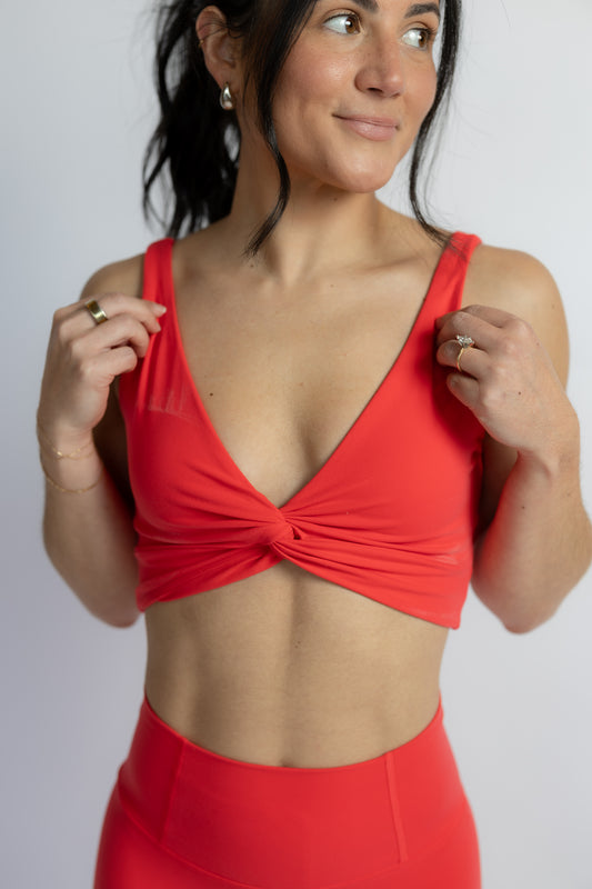 Woman wearing a sports bra top against a plain background
