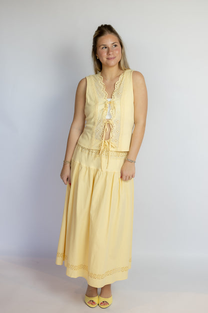 Woman wearing a yellow set against a plain background