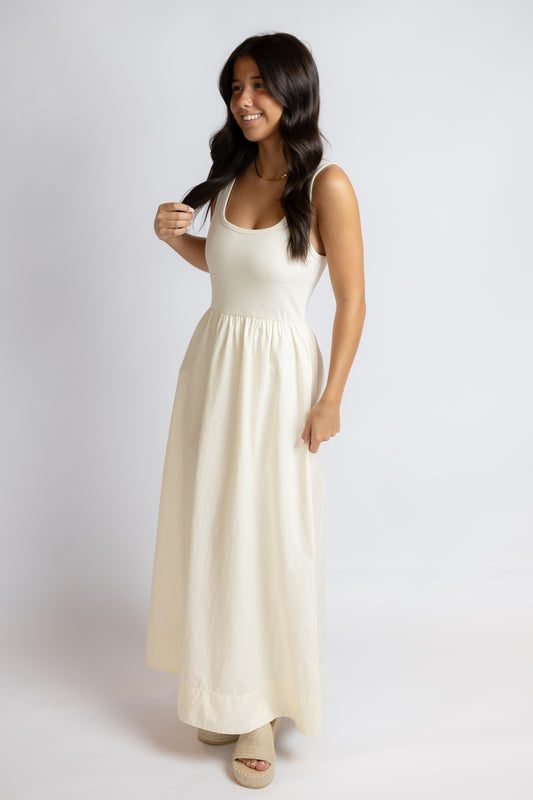 Woman wearing a white sleeveless dress on a plain background