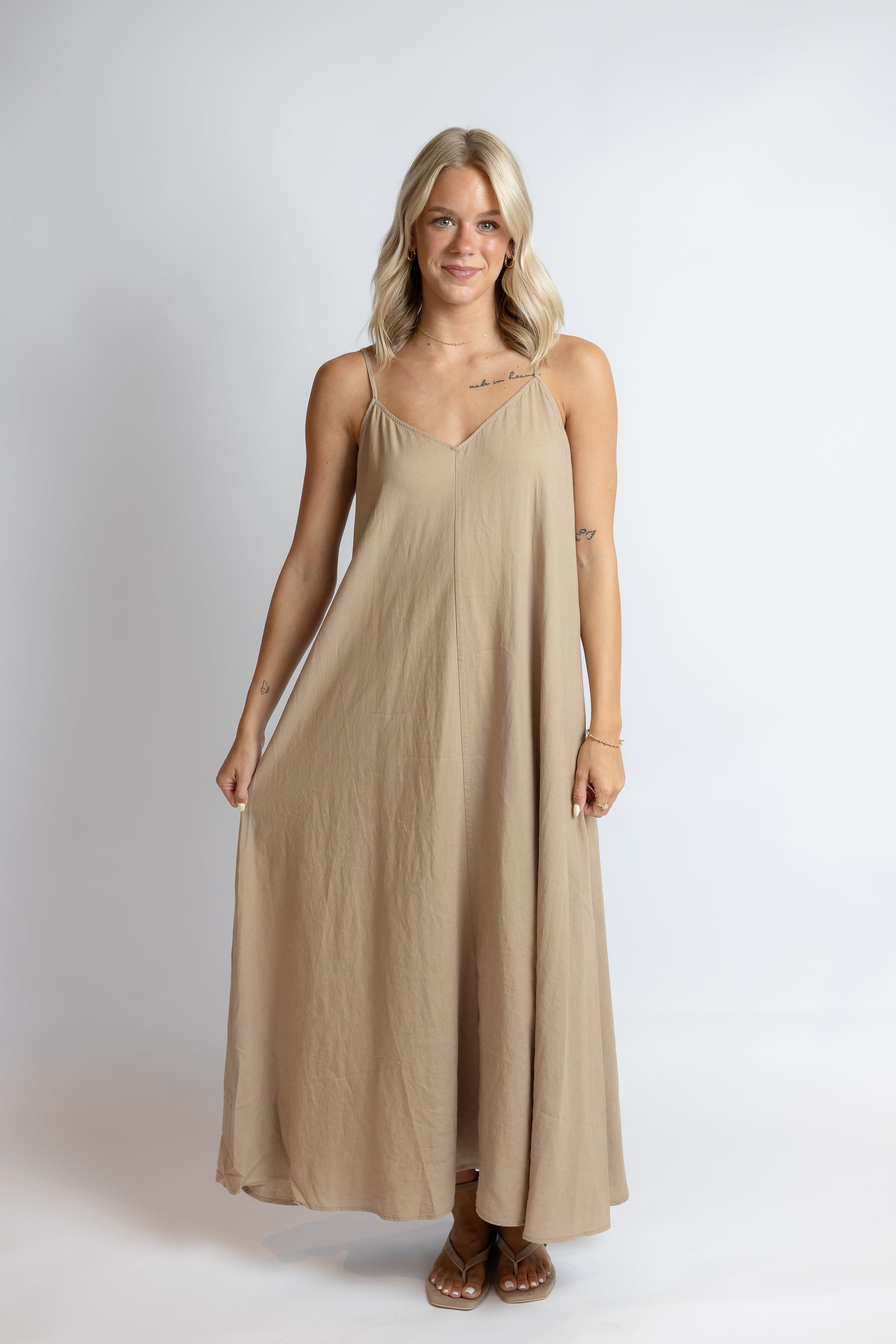 Woman wearing a beige dress against a white background