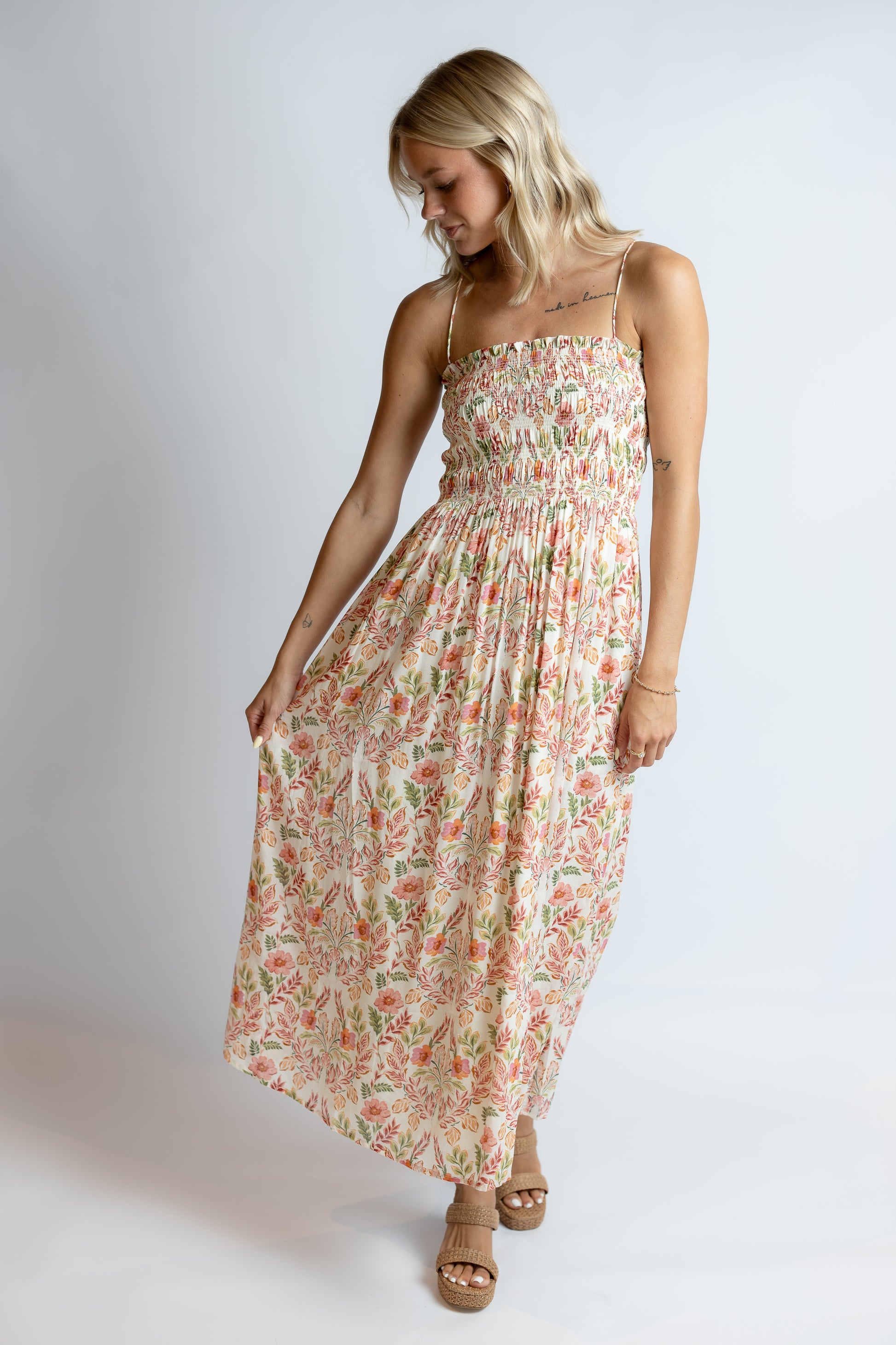 Woman wearing a floral dress on a plain background