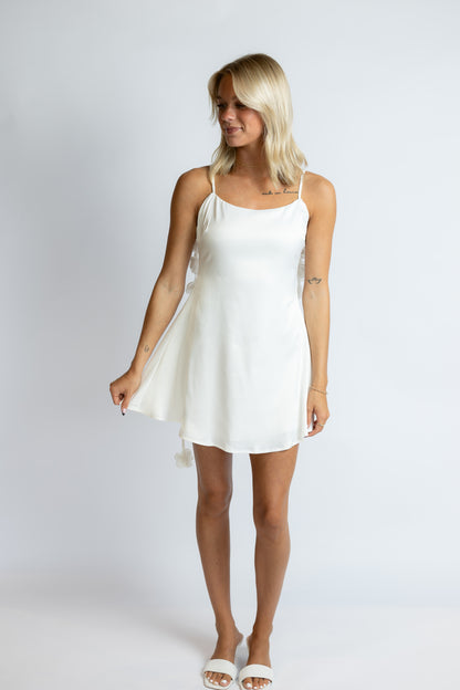 Woman wearing a white dress against a plain background