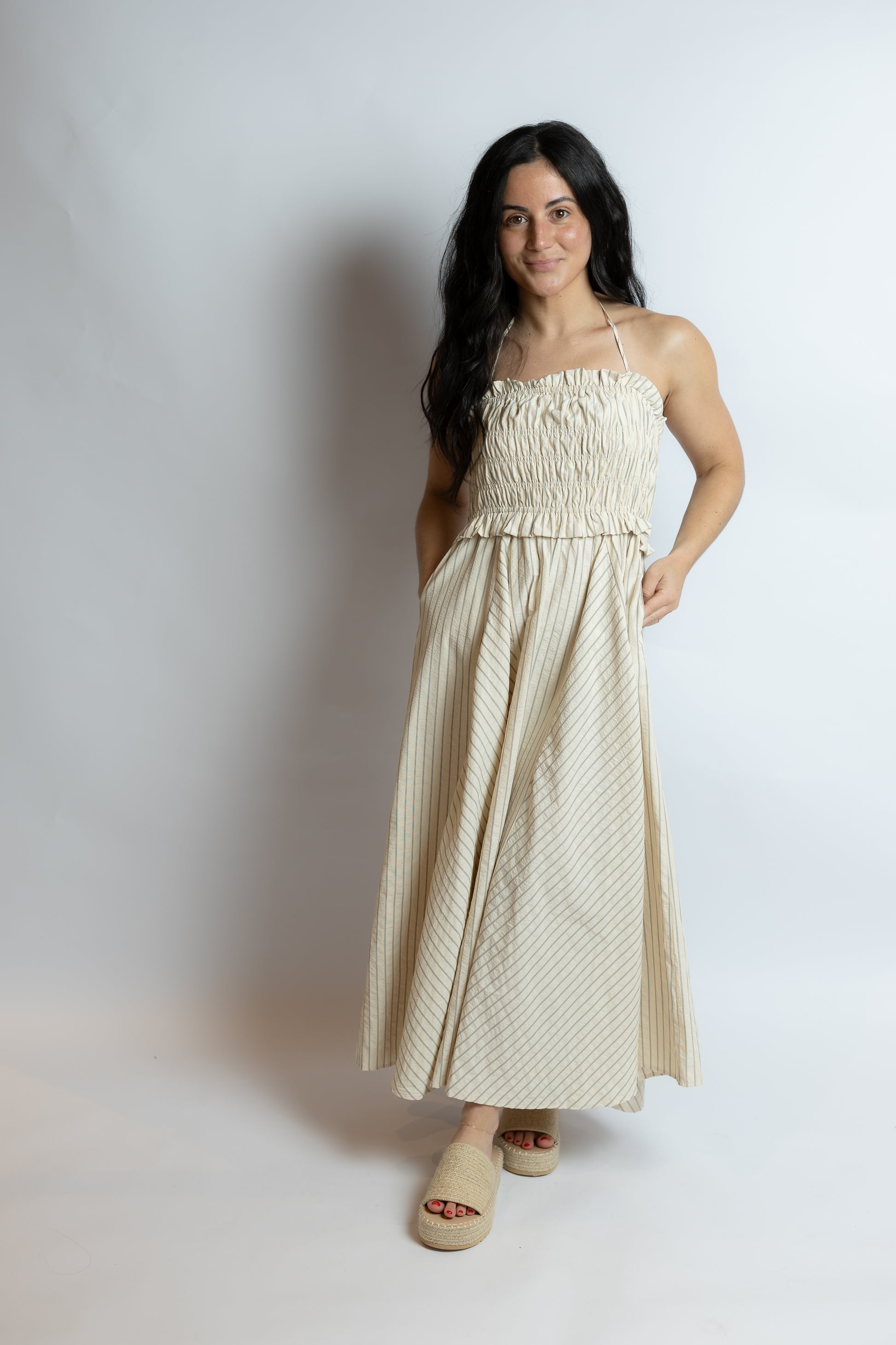 Woman wearing a beige dress against a plain background