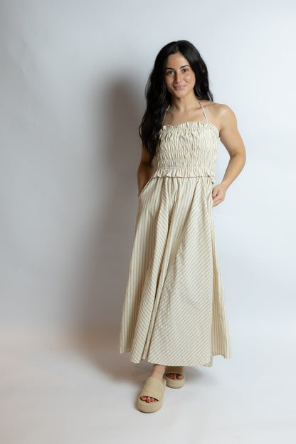 Woman wearing a beige dress against a plain background