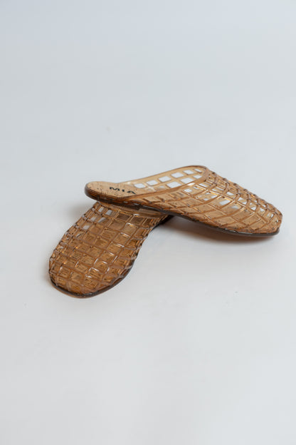 Pair of brown jelly flat sandals on a light gray background