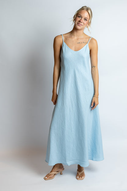 Woman wearing a light blue dress on a plain background