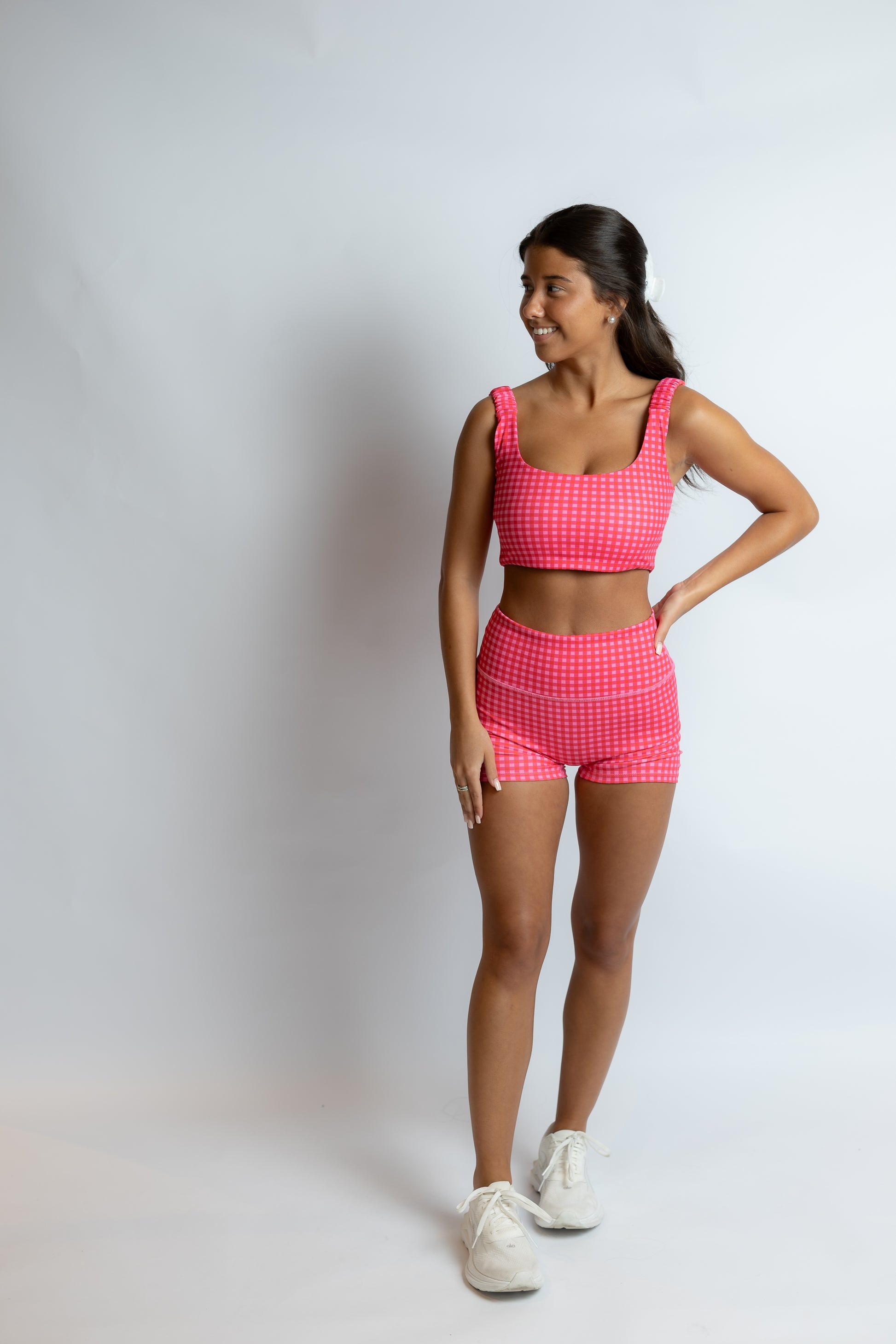 Woman wearing a pink checkered outfit on a white background