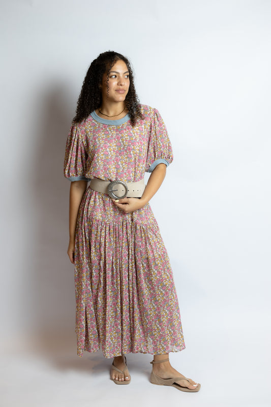 Woman wearing a floral dress holding a belt on a white background
