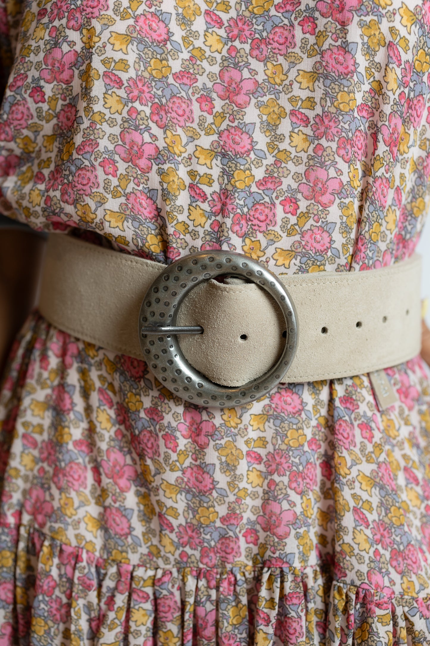 Floral dress with a beige belt and large decorative buckle.