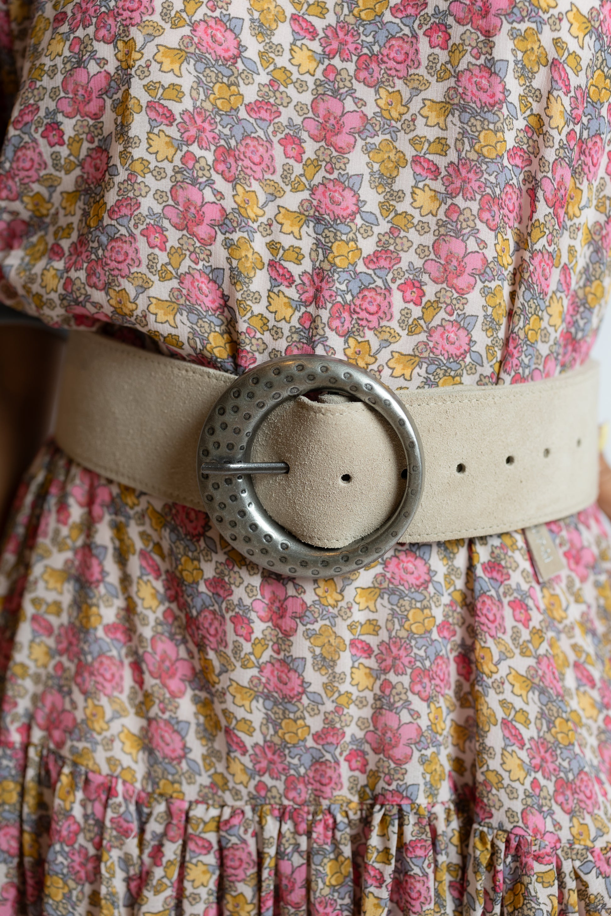Floral dress with a beige belt and large decorative buckle.