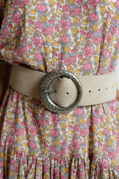 Floral dress with a beige belt and large decorative buckle.