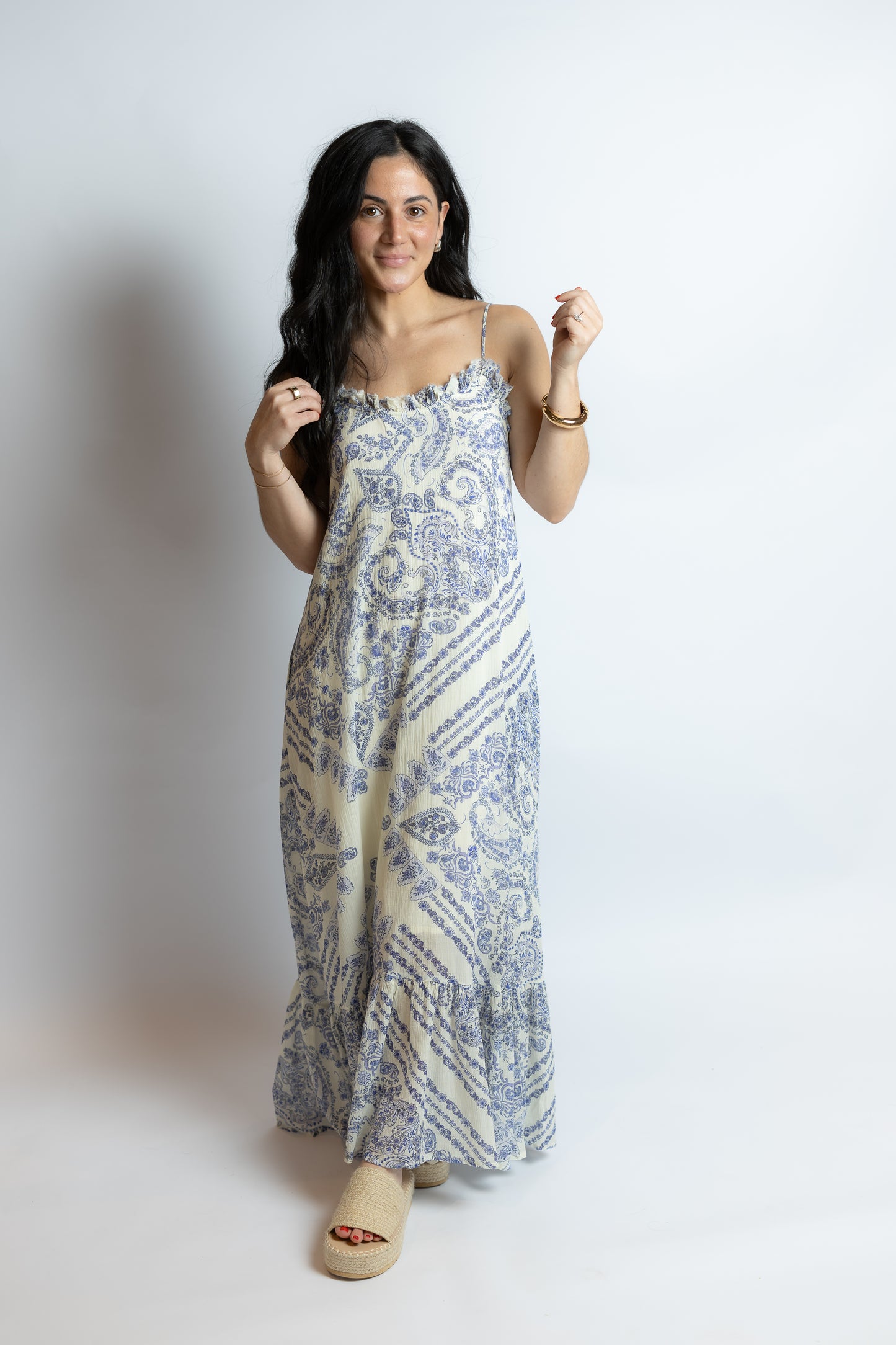Woman wearing a blue and white patterned dress on a plain background