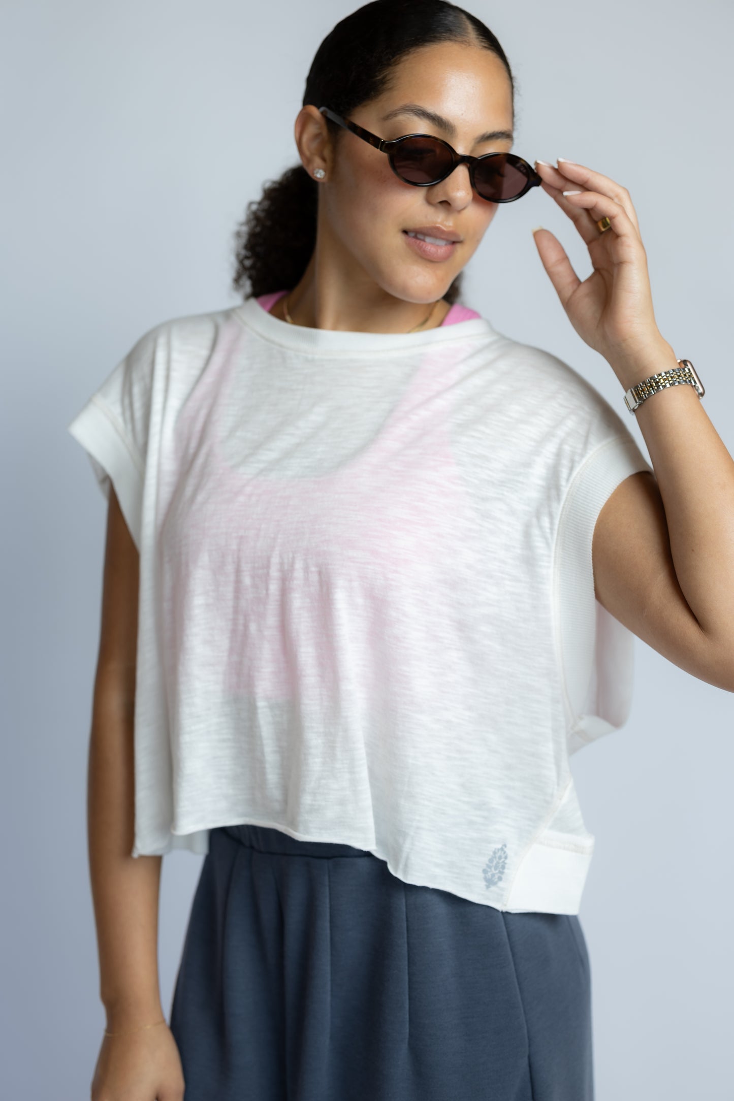Model wearing the Free People Movement My Time Tee in White featuring an oversized fit and criss-cross cutout back detail.