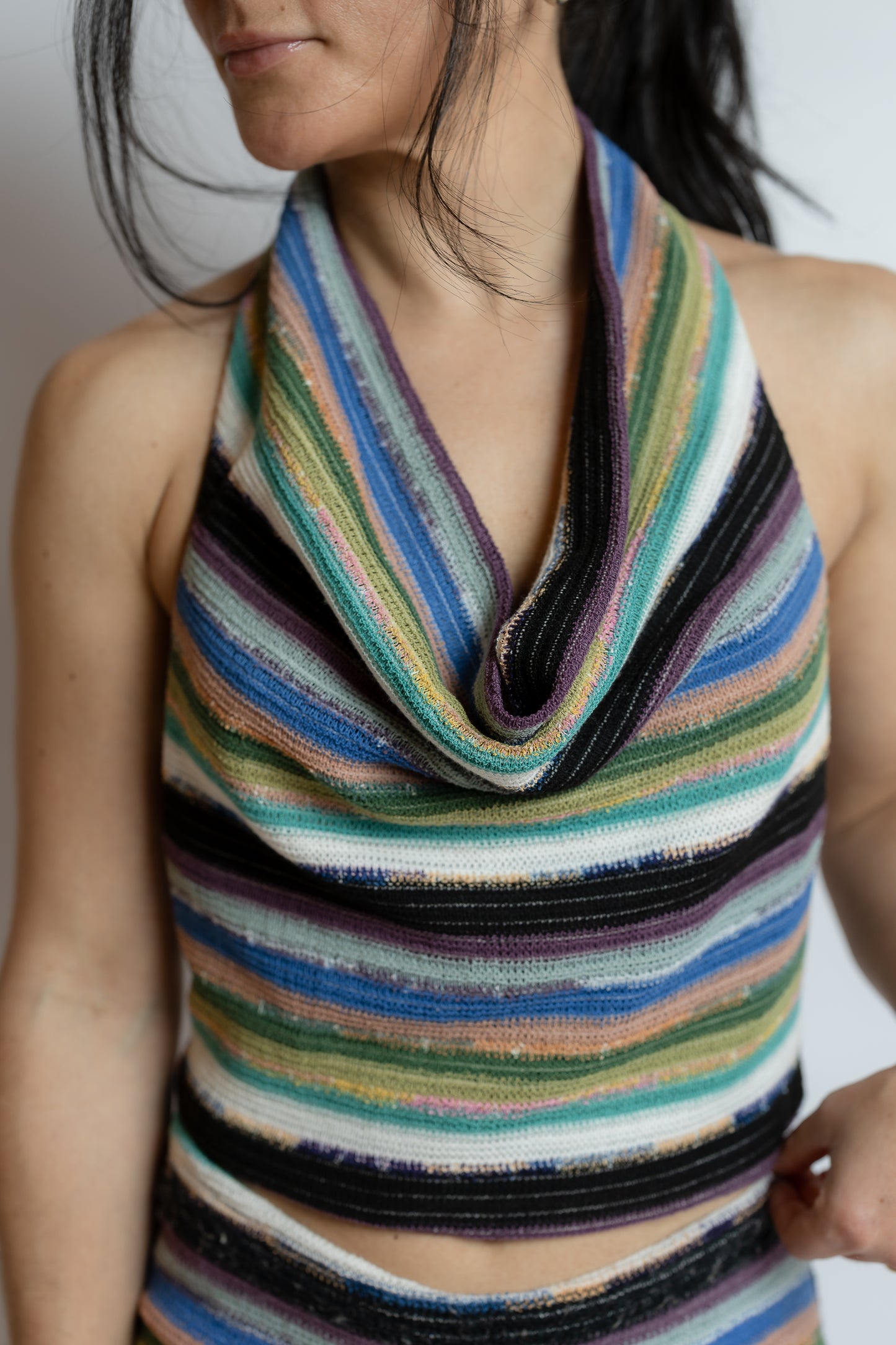 Multicolored striped sleeveless top worn by a person against a neutral background