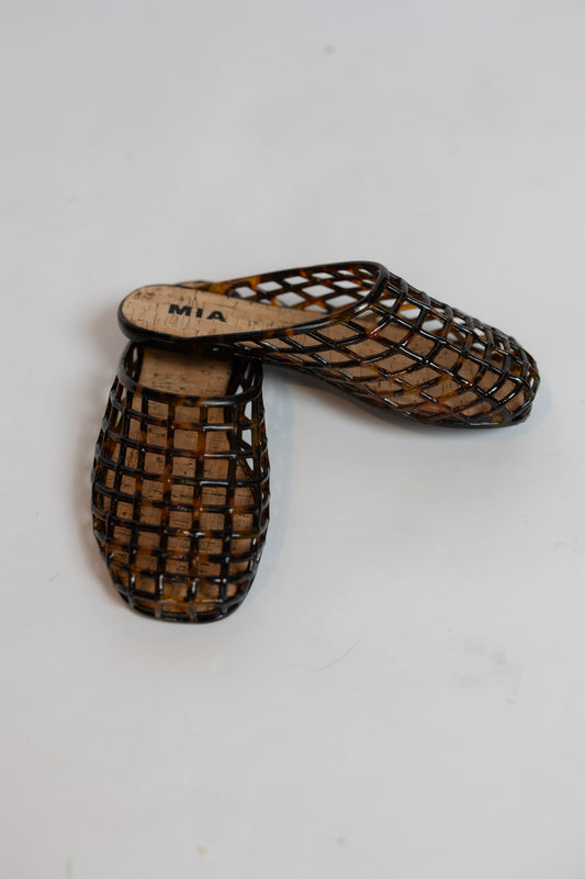 A pair of open-toe woven mule sandals with a dark brown basketweave pattern over a tan cork-like footbed, shown on a plain white background.