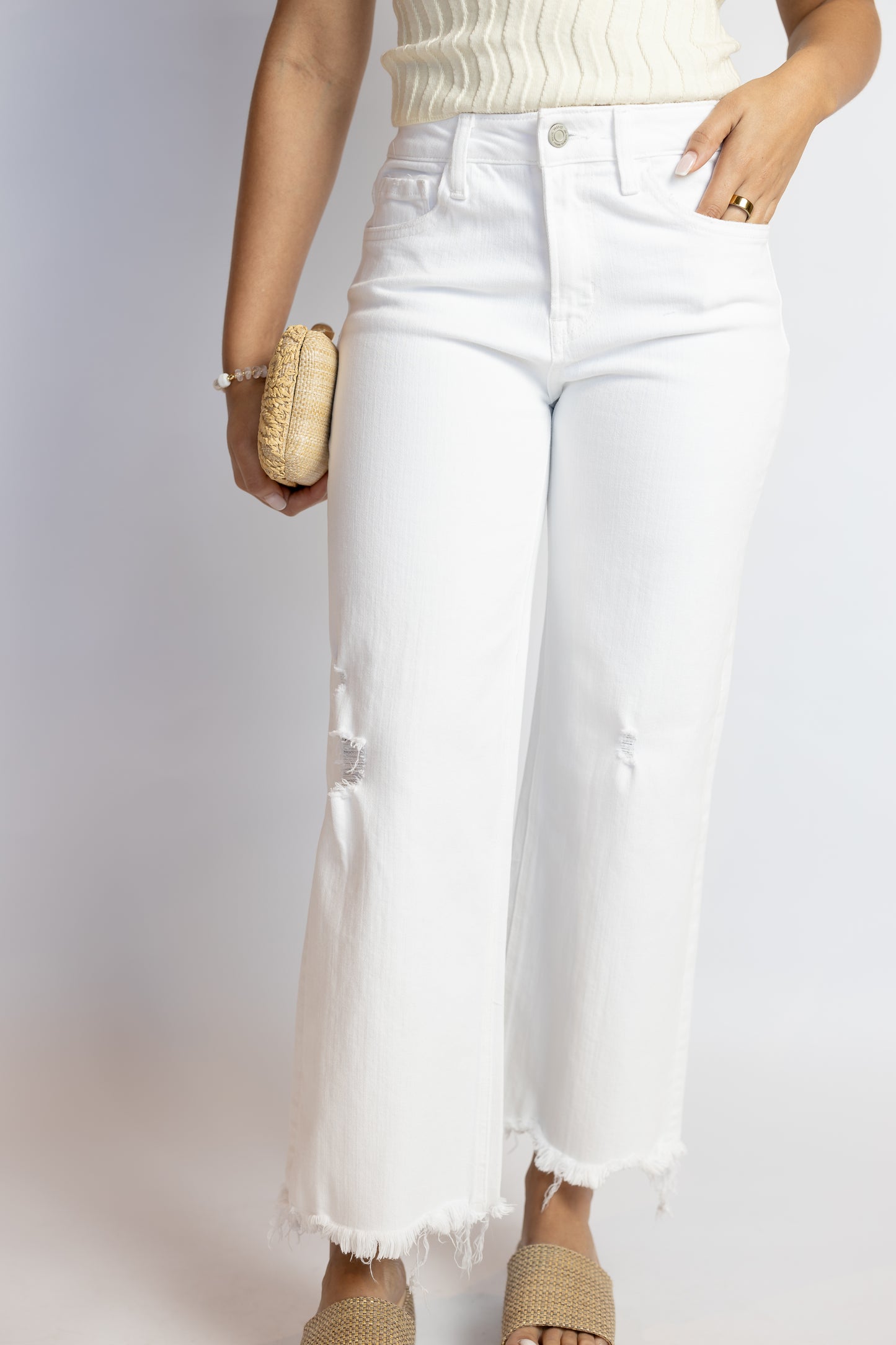 Person wearing white jeans with a plain background