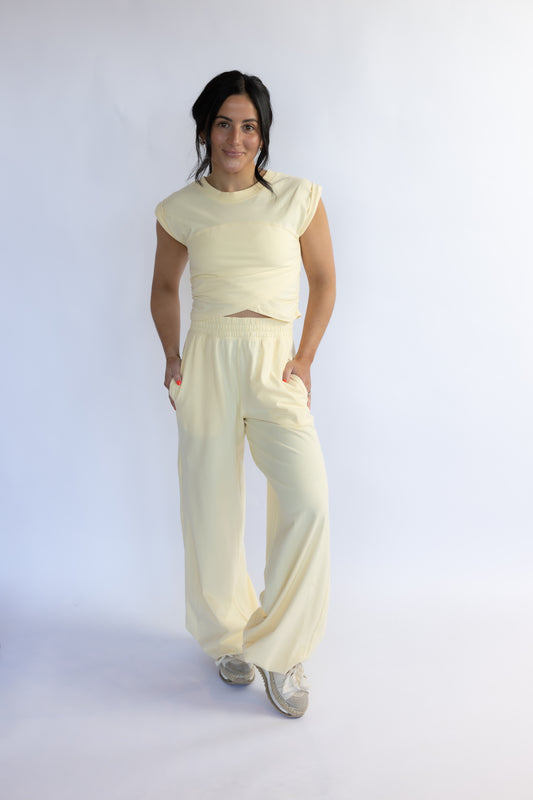 Woman wearing a cream-colored outfit on a white background